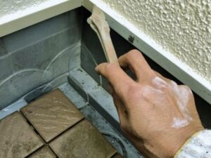 住宅の水切り部分を塗装している様子
